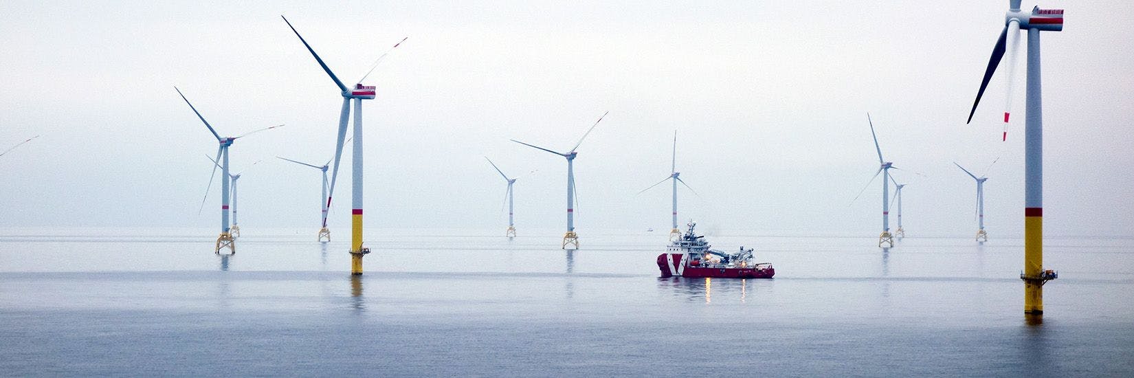 Offshore ship at sea, with wind mills around
